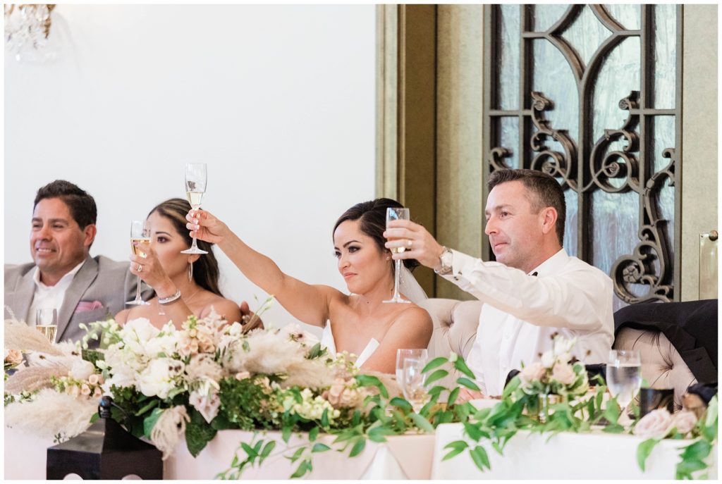 bridal party toasting during speeches at wedding reception