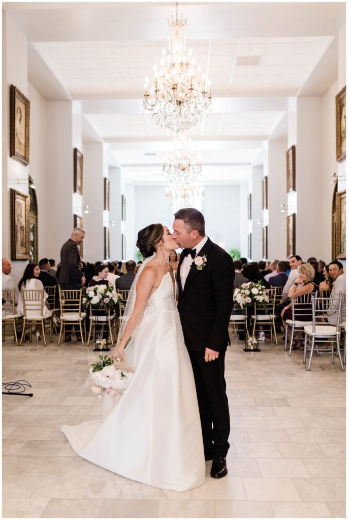 bride and groom kissing as newly married couple at european chic wedding