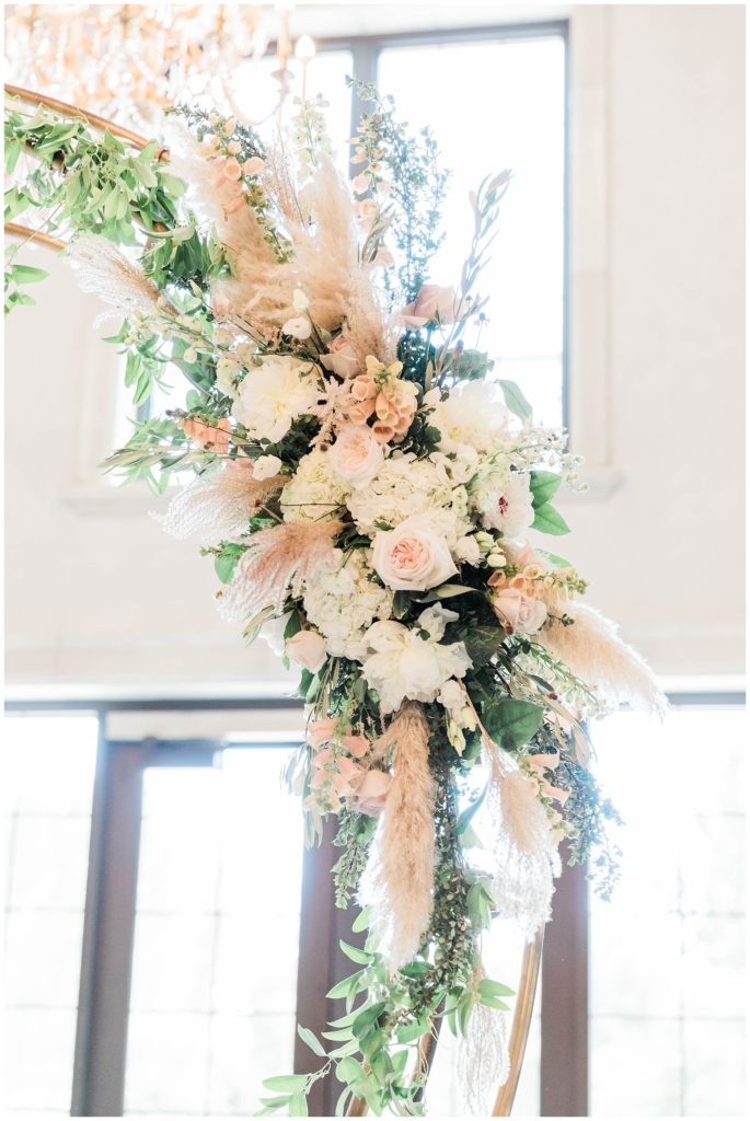 white and blush floral arch detail at european chic wedding