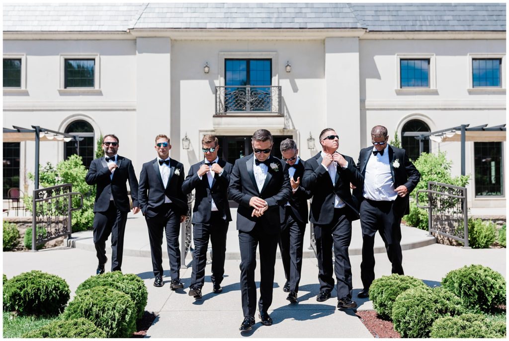 groom walking with groomsmen in sunglasses during outdoor bridals