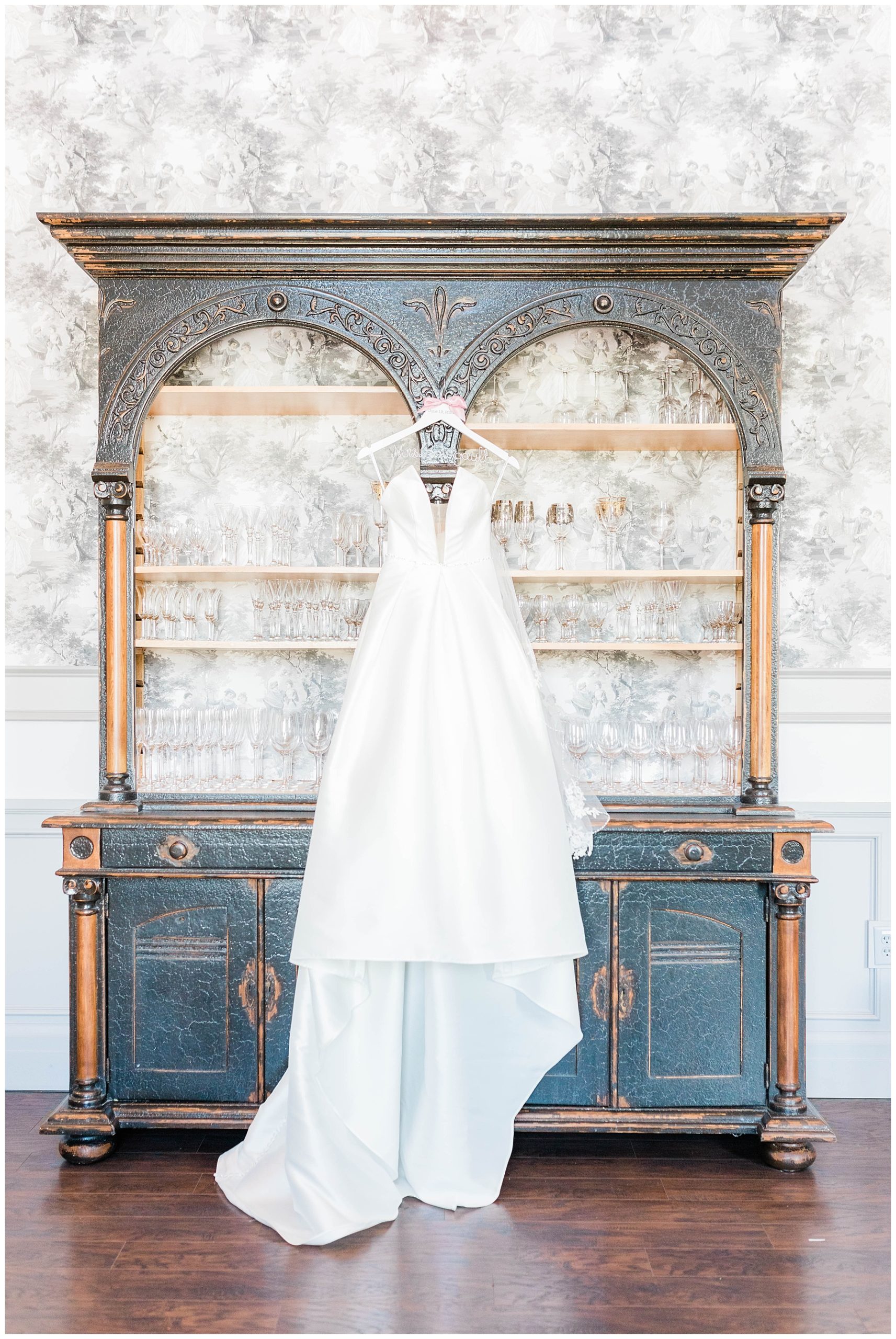bridal gown hanging from vintage bookshelf at european chic wedding