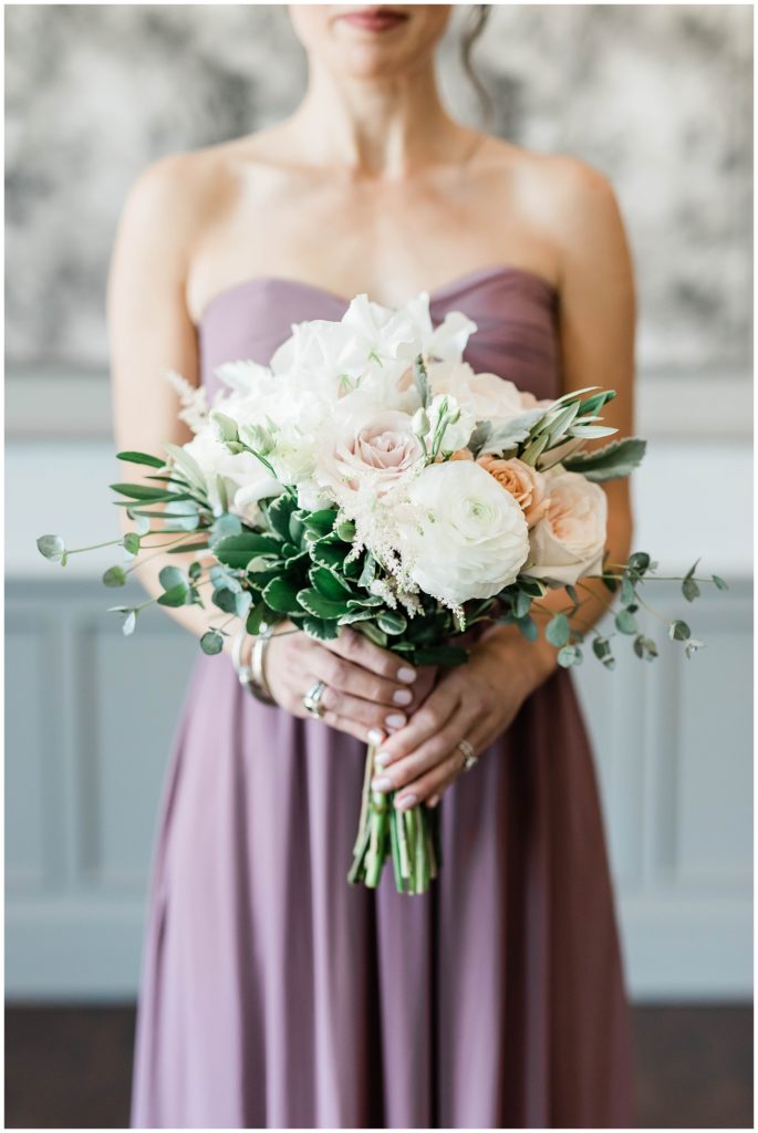 purple bridesmaids dress holding white and pink floral bouquet at european chic wedding