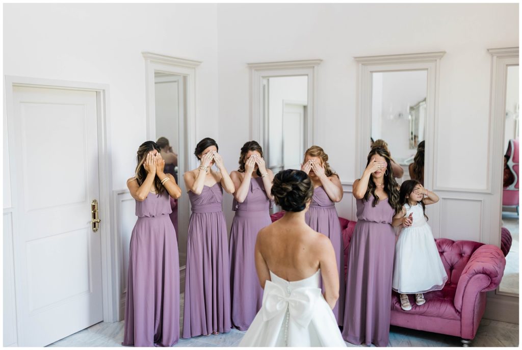 bridesmaids closing eyes during first look with bride