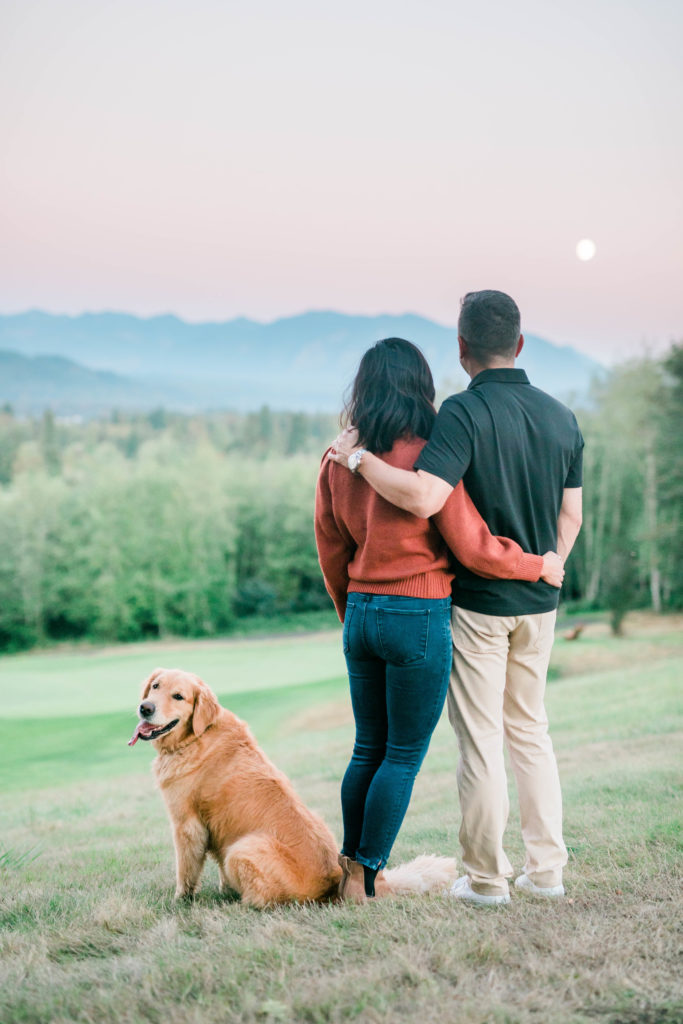 couple looking at the sunset standing with their beautiful dog Stella