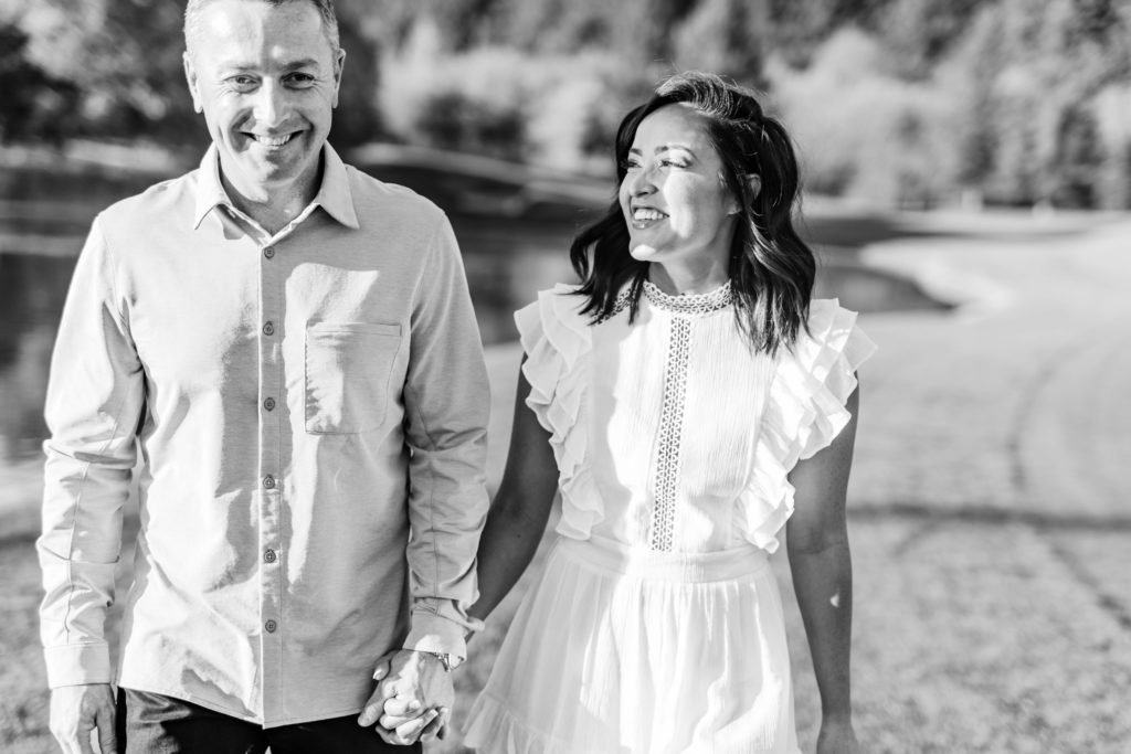 engaged couple walking hand in hand during golf course engagement session