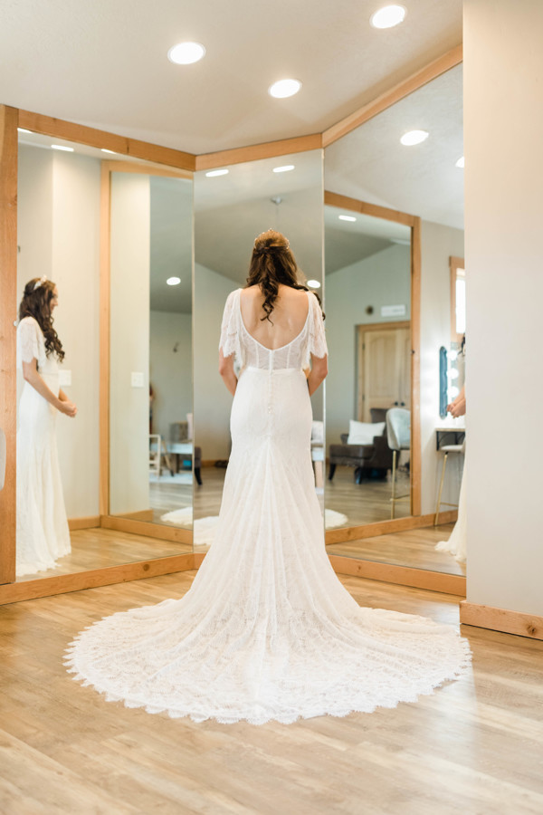 bride looking in the mirror on wedding day in boho chic carefree dress