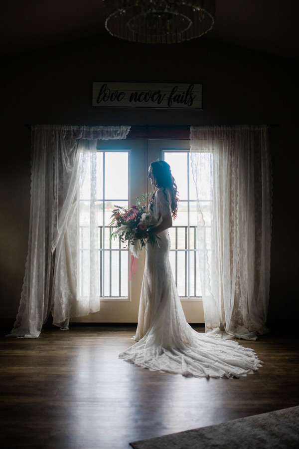bride holding her wedding bouquet as she stands in front of a bright window at her Boise Idaho wedding venue
