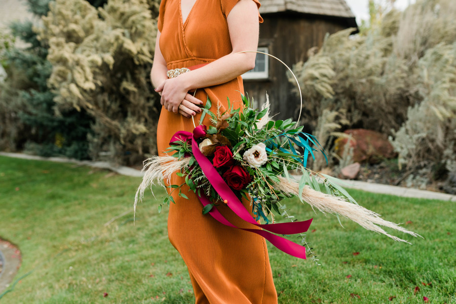 bridesmaid holding floral boho chic wreath at whimsical still water hollow wedding