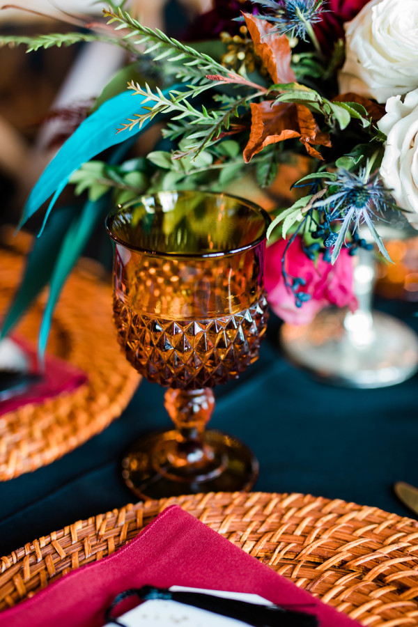 bronze goblet filled with florals on wedding tablescape at whimsical still water hollow wedding