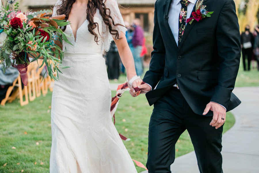 wedding couple holding hands walking out of ceremony