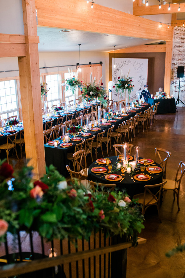 moody and cozy fall wedding reception with greenery and florals