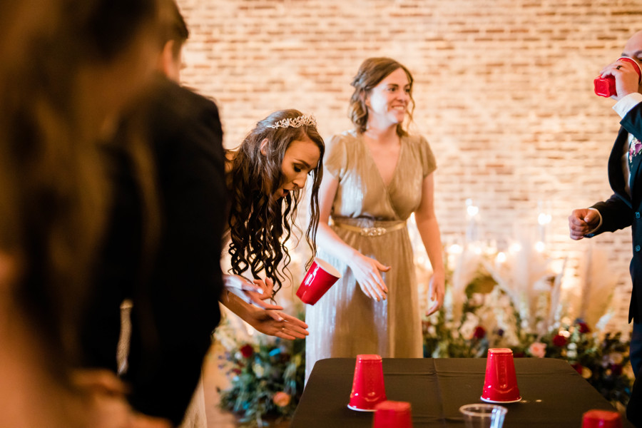 bride playing flip cup game about to win for her team