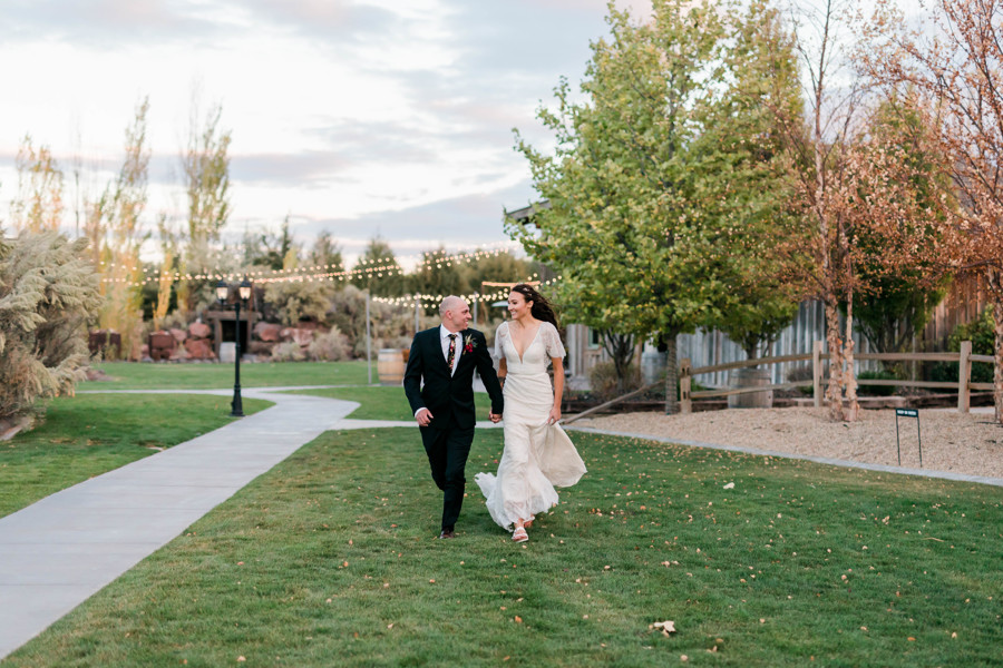 bride and groom running through field during whimsical still water hollow wedding bridal portraits