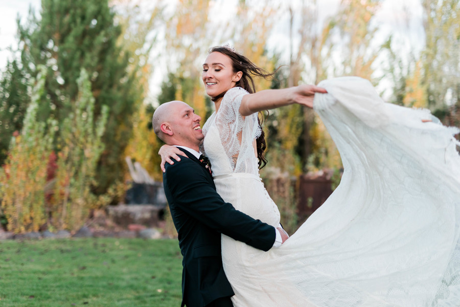 groom lifting up bride and spinning around on whimsical still water hollow wedding day 