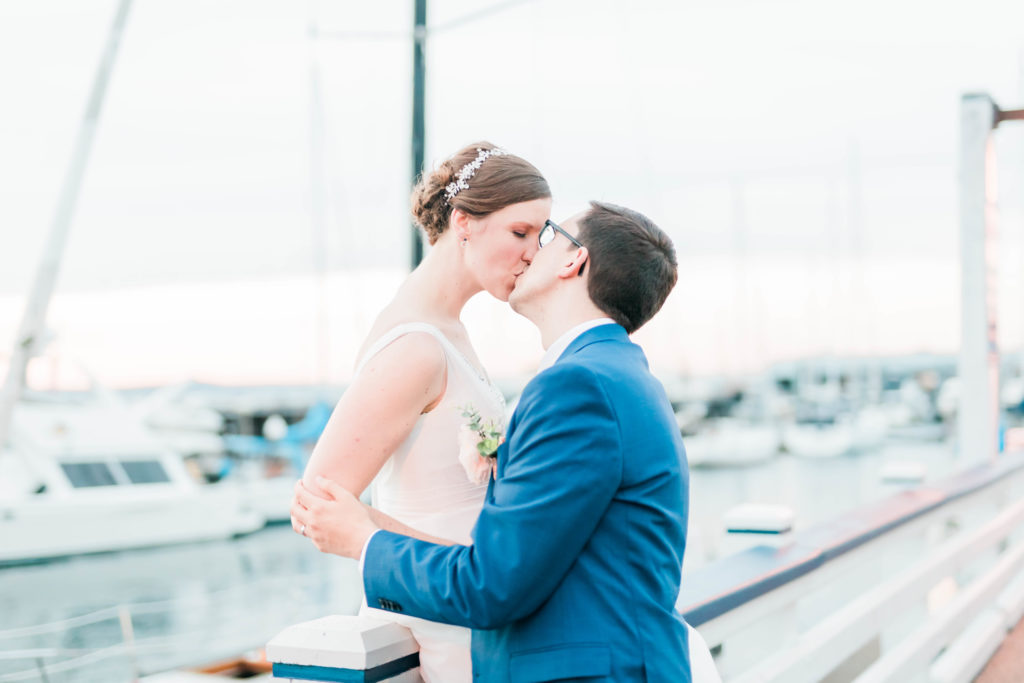 bride on top of railing at marina during nautical wedding bridals session