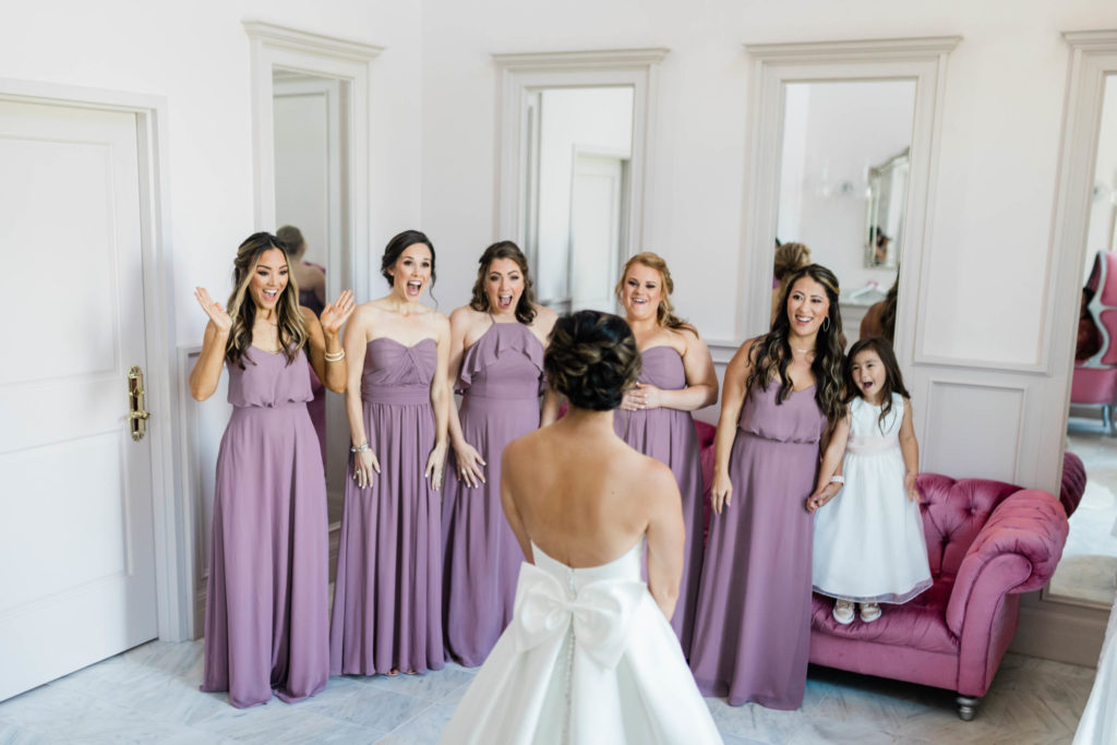 bride having a first look with her bridesmaids in her bride room 