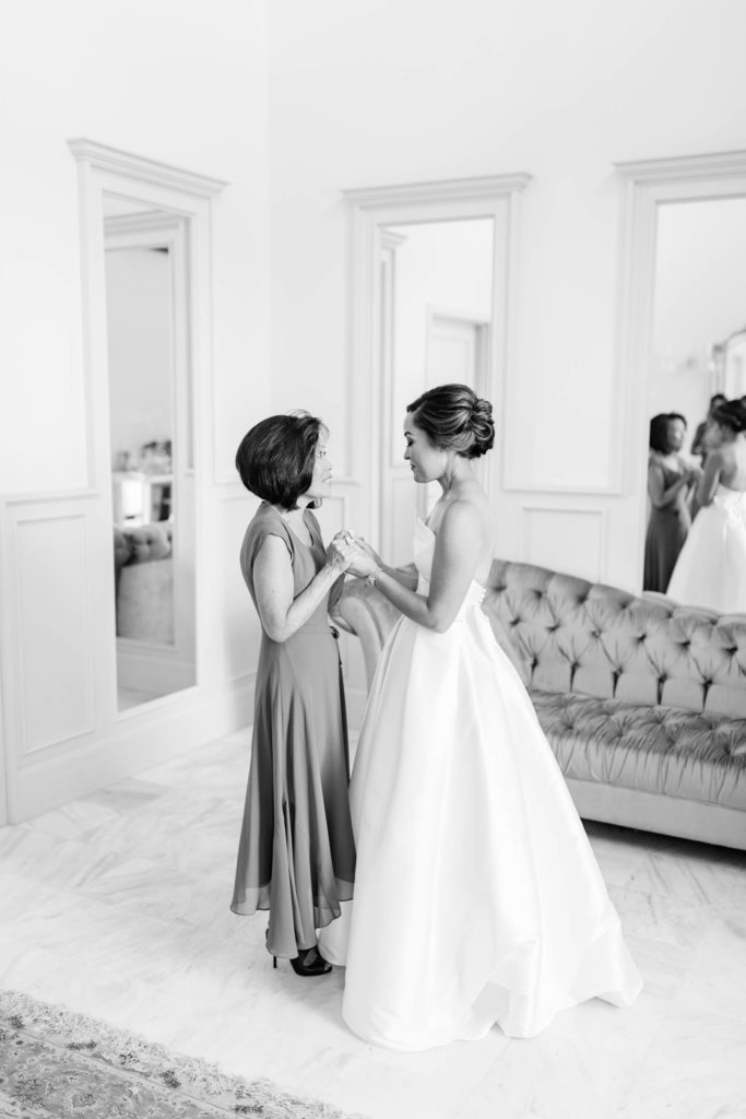 black and white image of bride holding hands with her mother in her bridal rom at Boise wedding venue