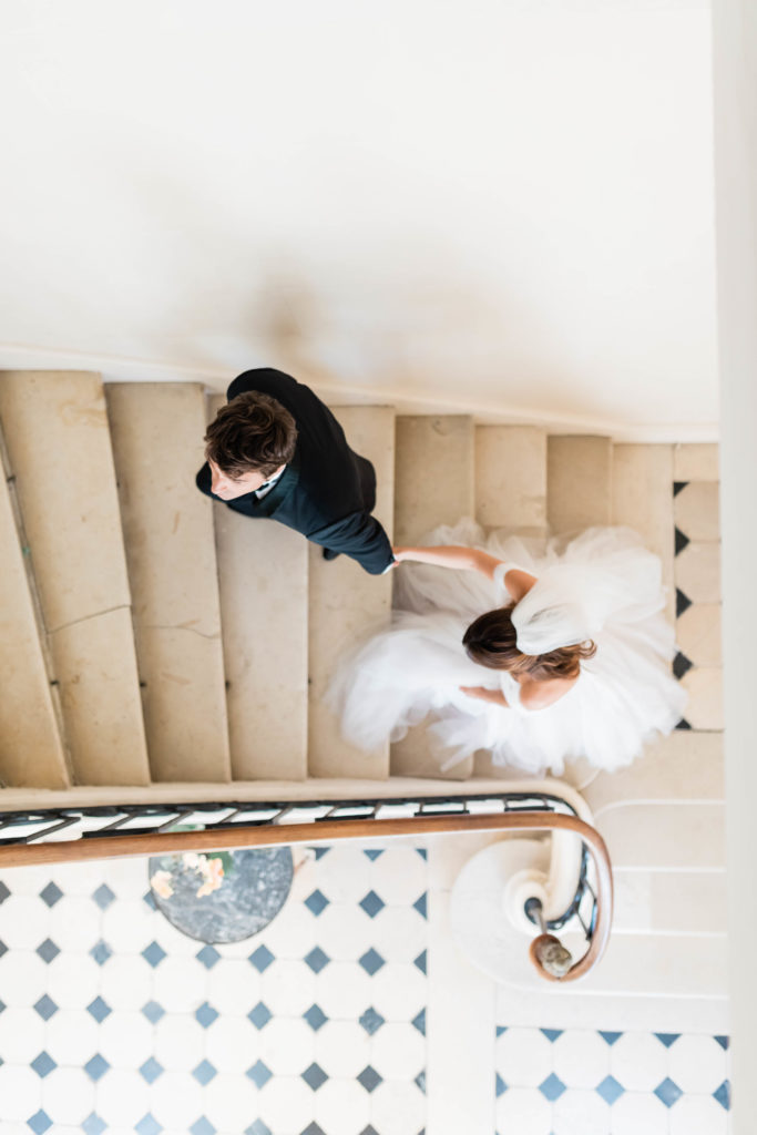 bride and groom holding hands and walking up a stair well at their Spring wedding venue in Boise