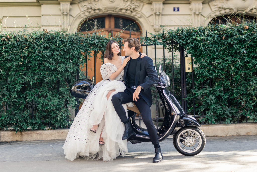 man and woman sitting on a parked motorcycle in Paris for their destination engagement session