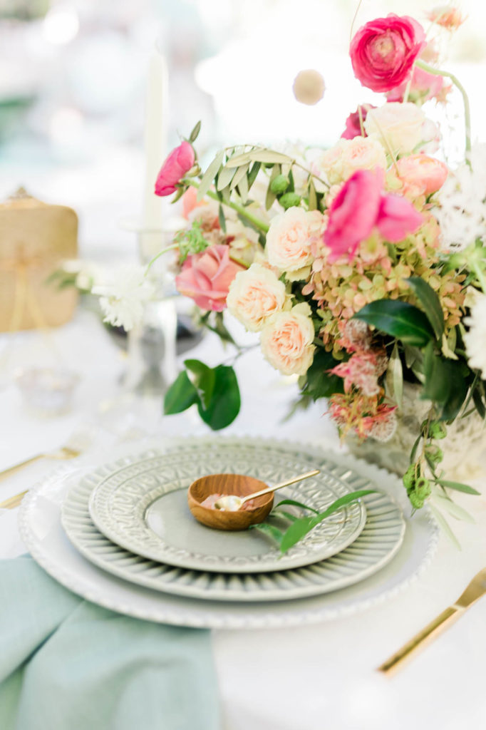 elegant spring wedding table setting with pink florals and sage green plates