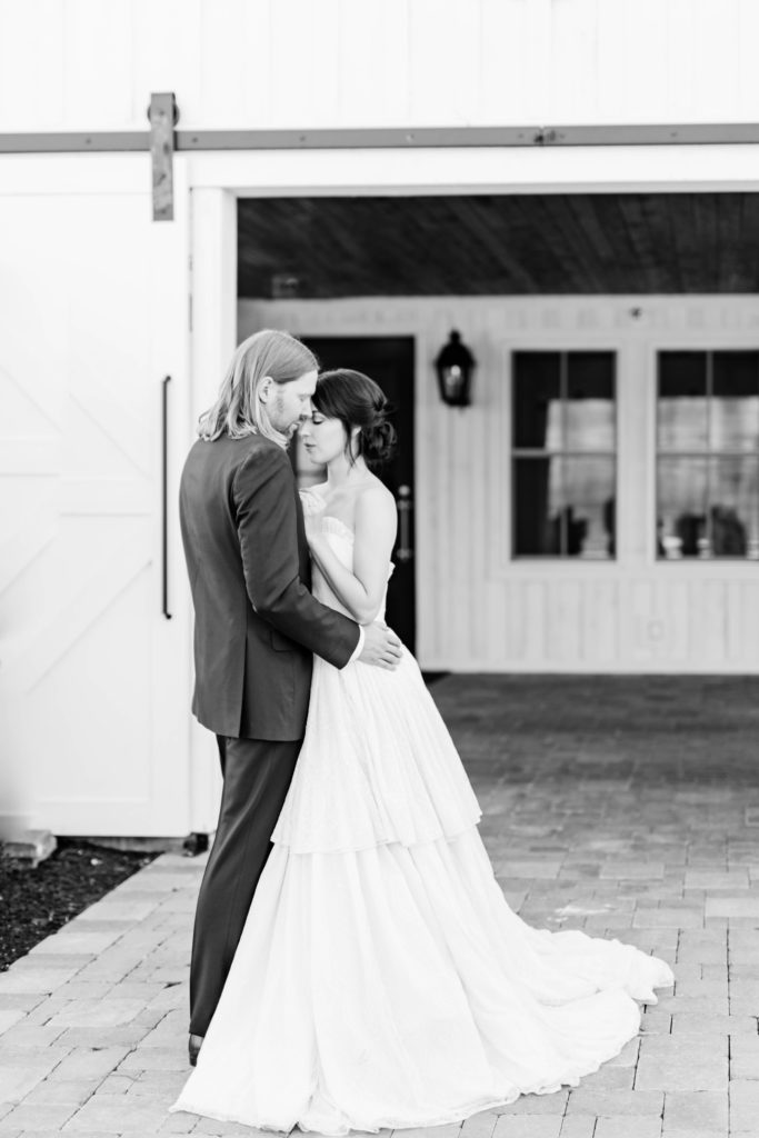 black and white wedding photos of bride and groom huggin outside of their Boise Idaho wedding venue during their summer wedding 