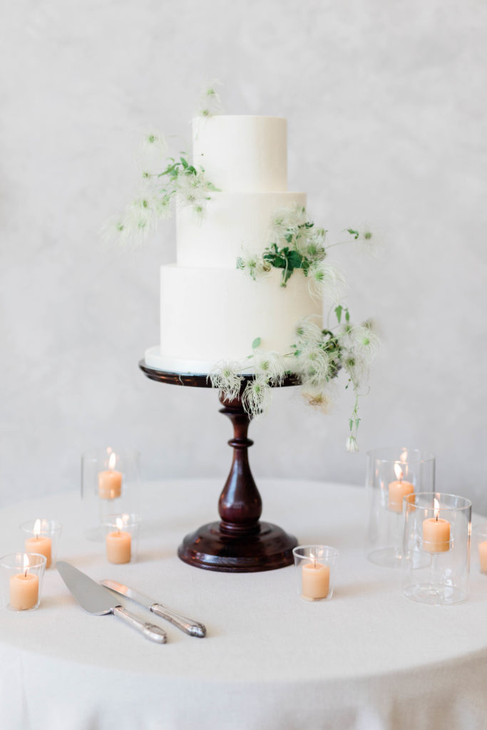 classic wedding cake with three tiers and greenery to decorate the cake