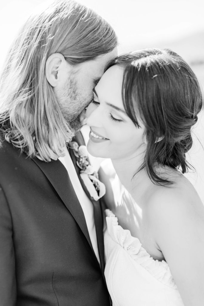 black and white bridals with groom whispering in brides ears captured by Boise wedding photographer