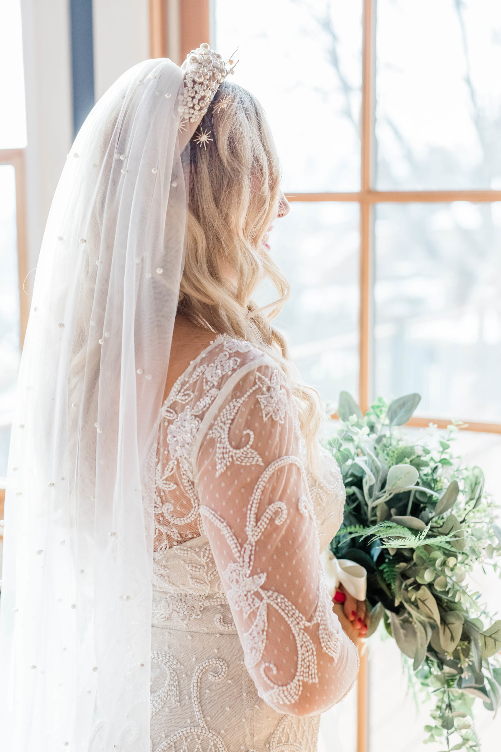 bride with long blonde hair wearing a bold headband and a long veil for her Boise Idaho wedding day 