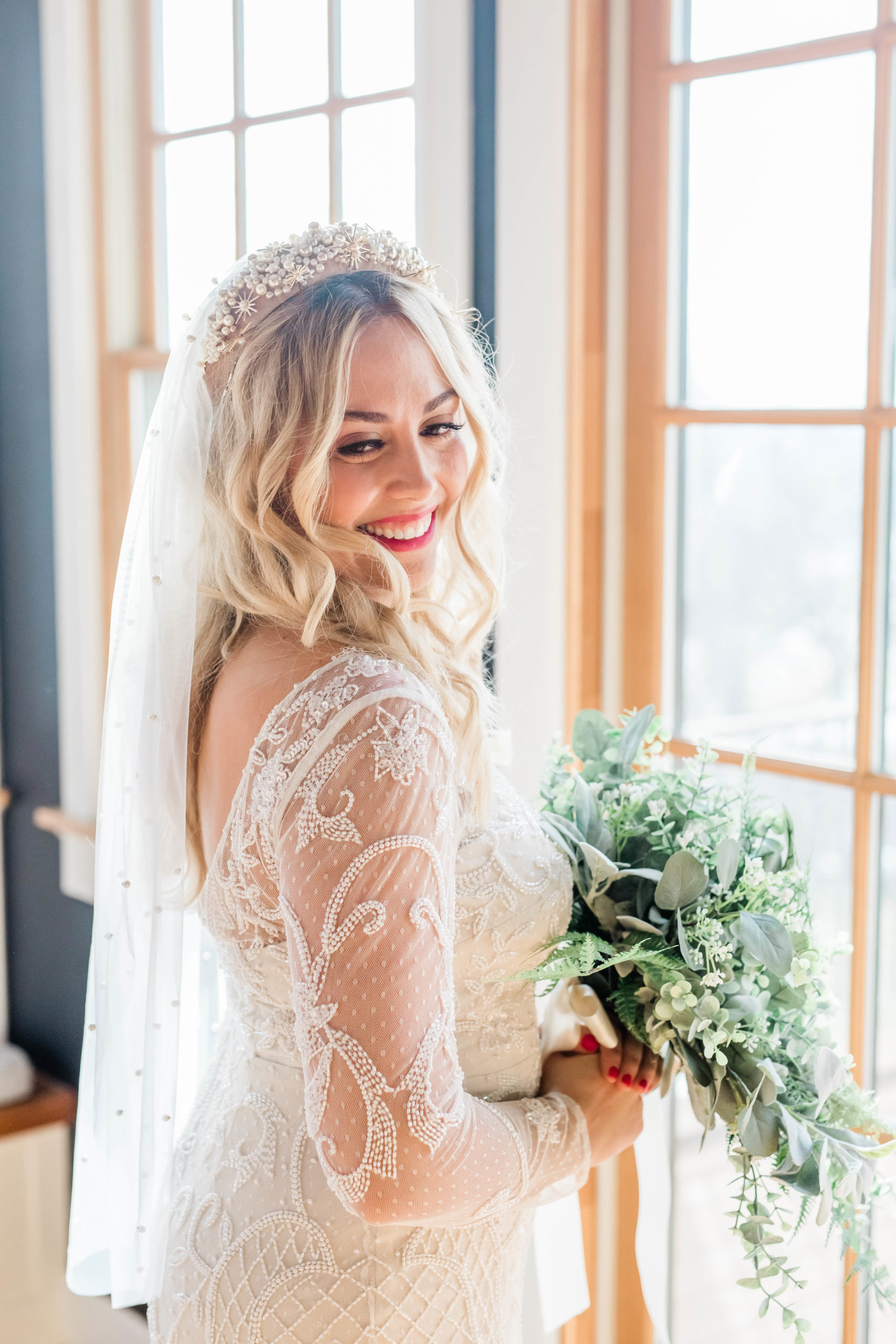 wedding hairstyle with long blonde curly hair with a star veil on a bride with a lace wedding gown