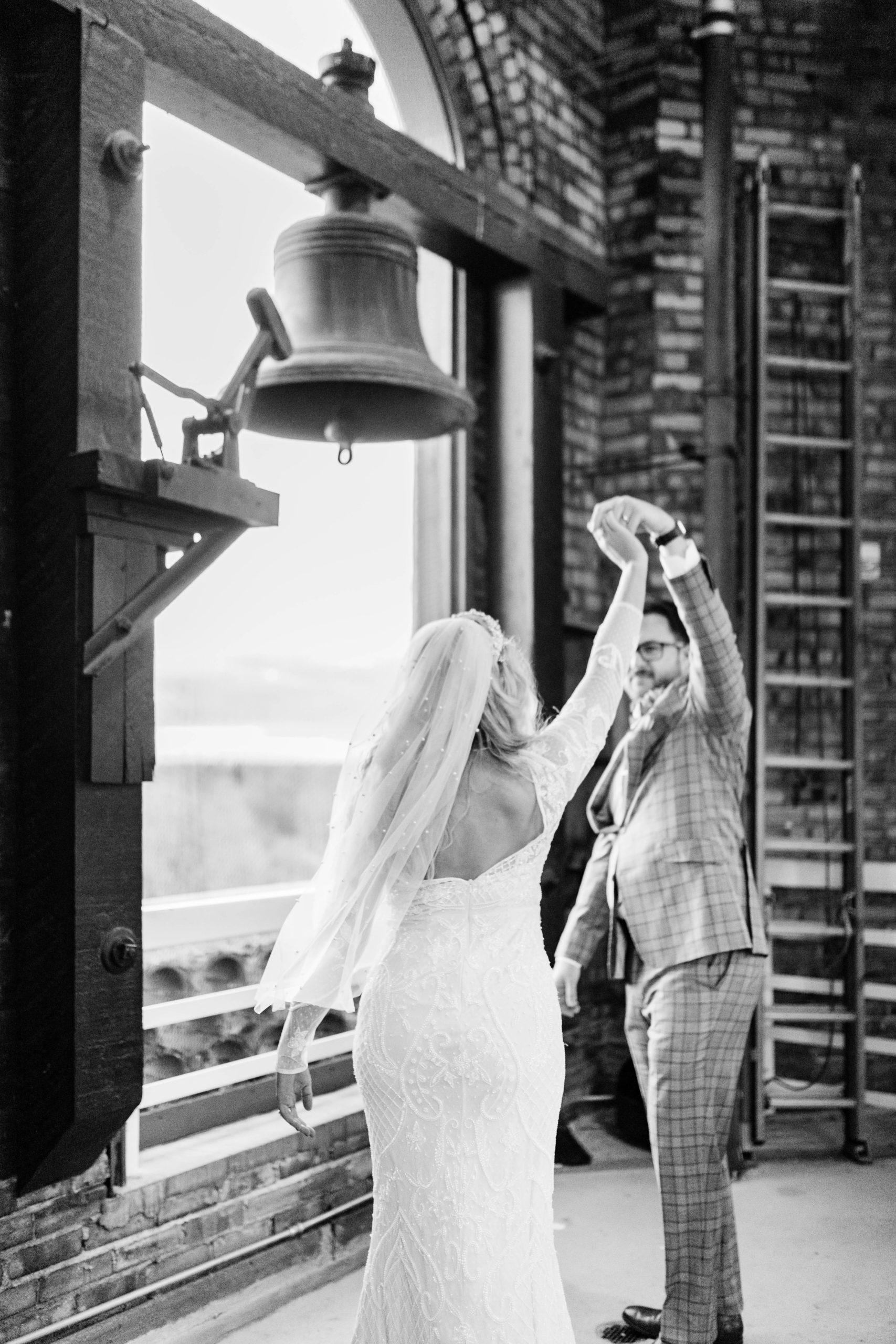 black and white wedding photo of bride and groom sitting together and laughing
