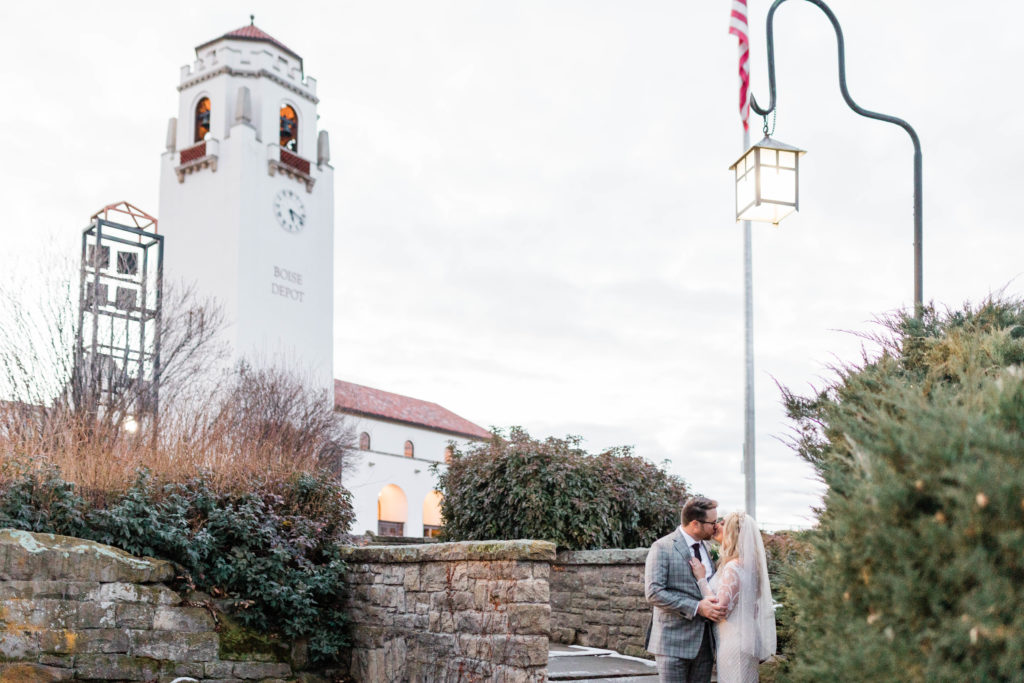 bride and groom embrace outside of Boise wedding venue as their Boise wedding photographer captures their love story