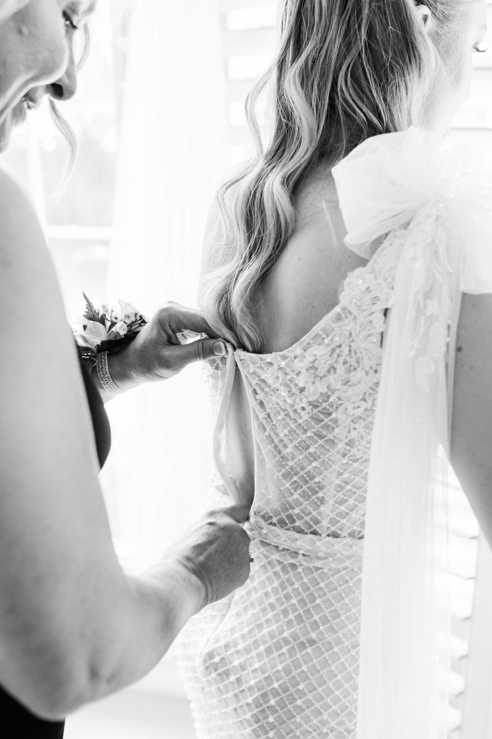 black and white picture of bride getting zipped up for her wedding day in her Boise bridal suite