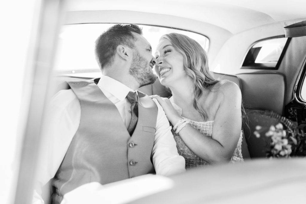 blacka nd white wedding photo taken by Boise wedding photographer of bride and groom sitting in a car together