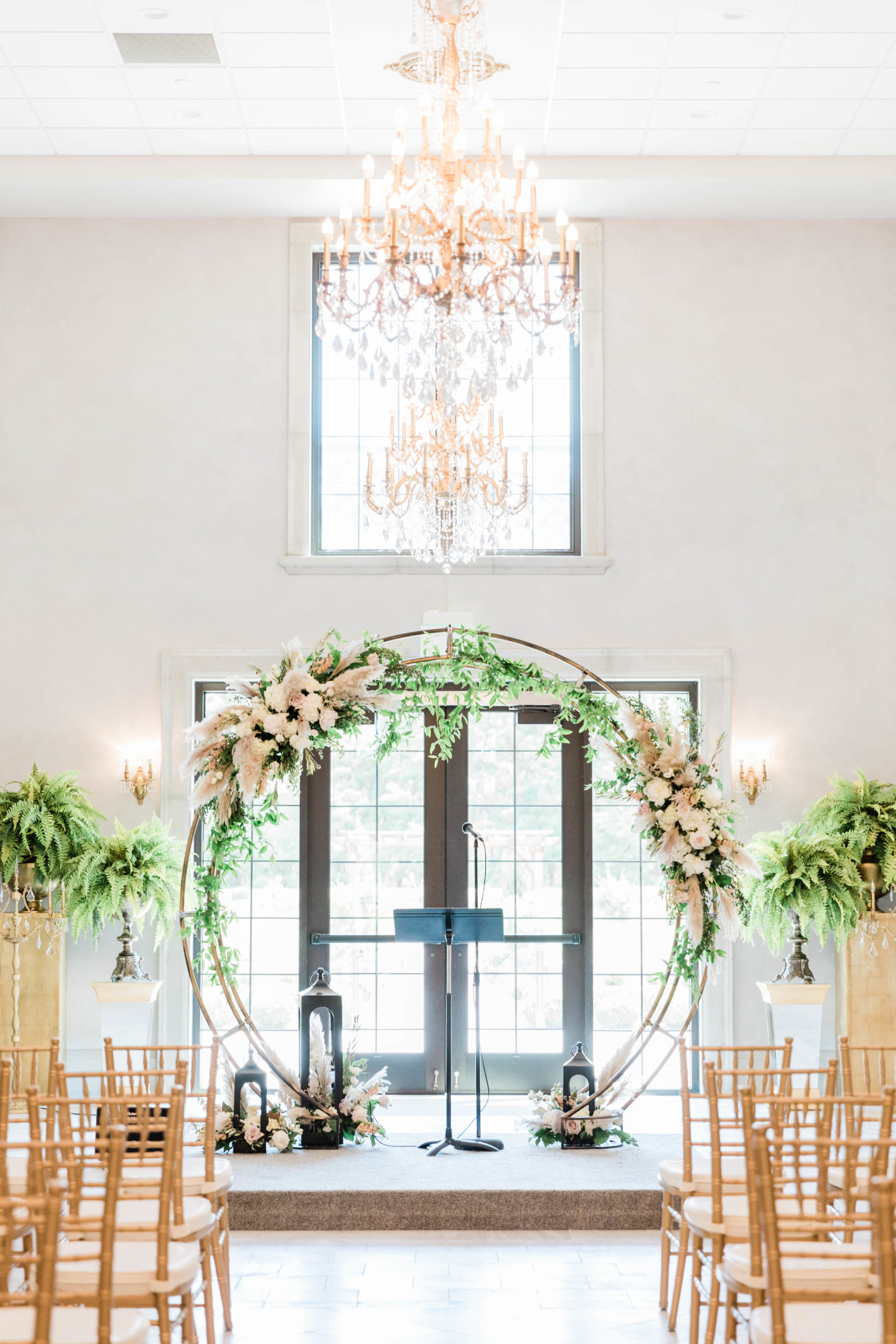 Boise Idaho luxury wedding venue ceremony space with tall bright windows and a circle arch decorated with florals 