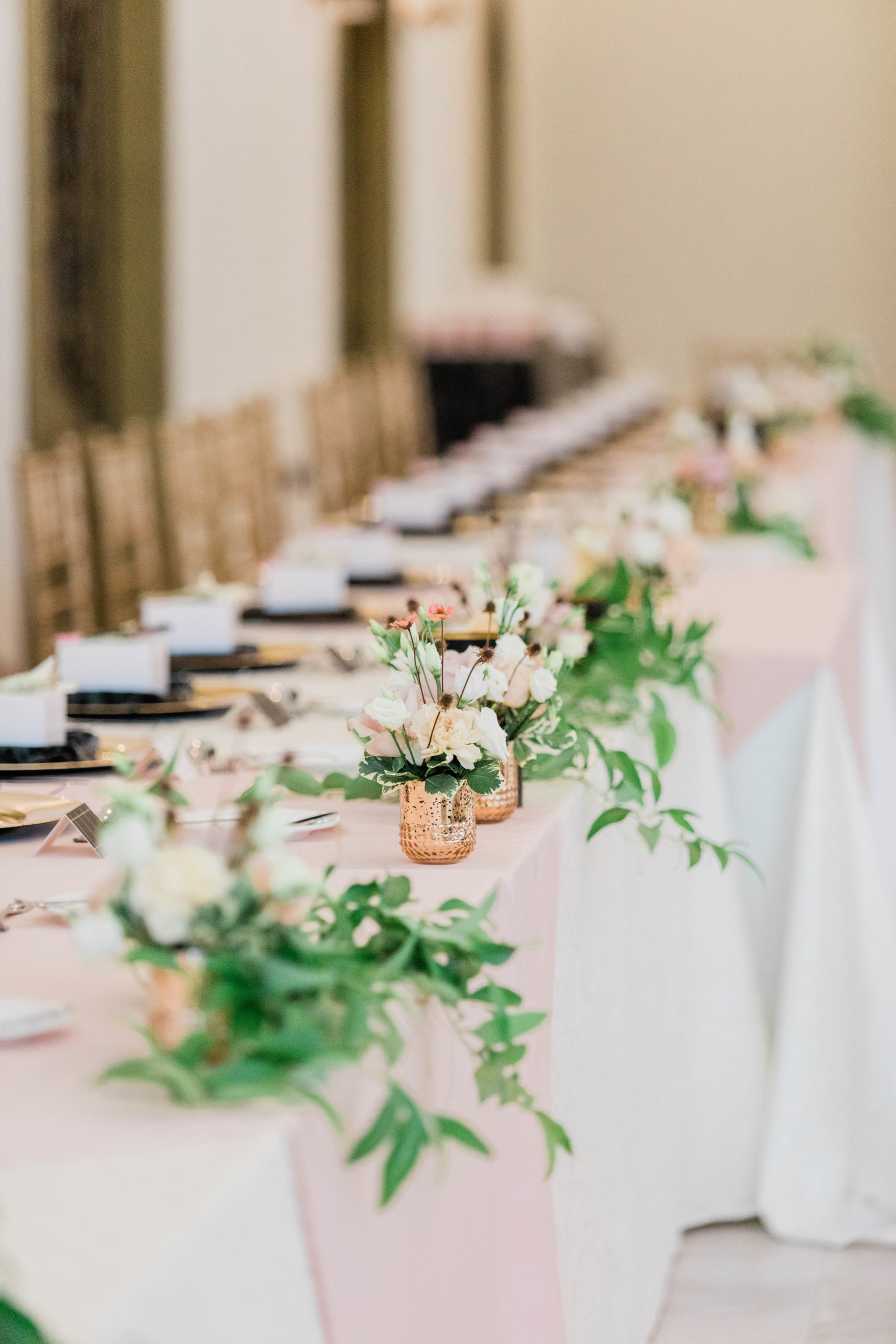 Boise wedding photographer captures wedding venue with long tables set up and pink florals as centerpieces