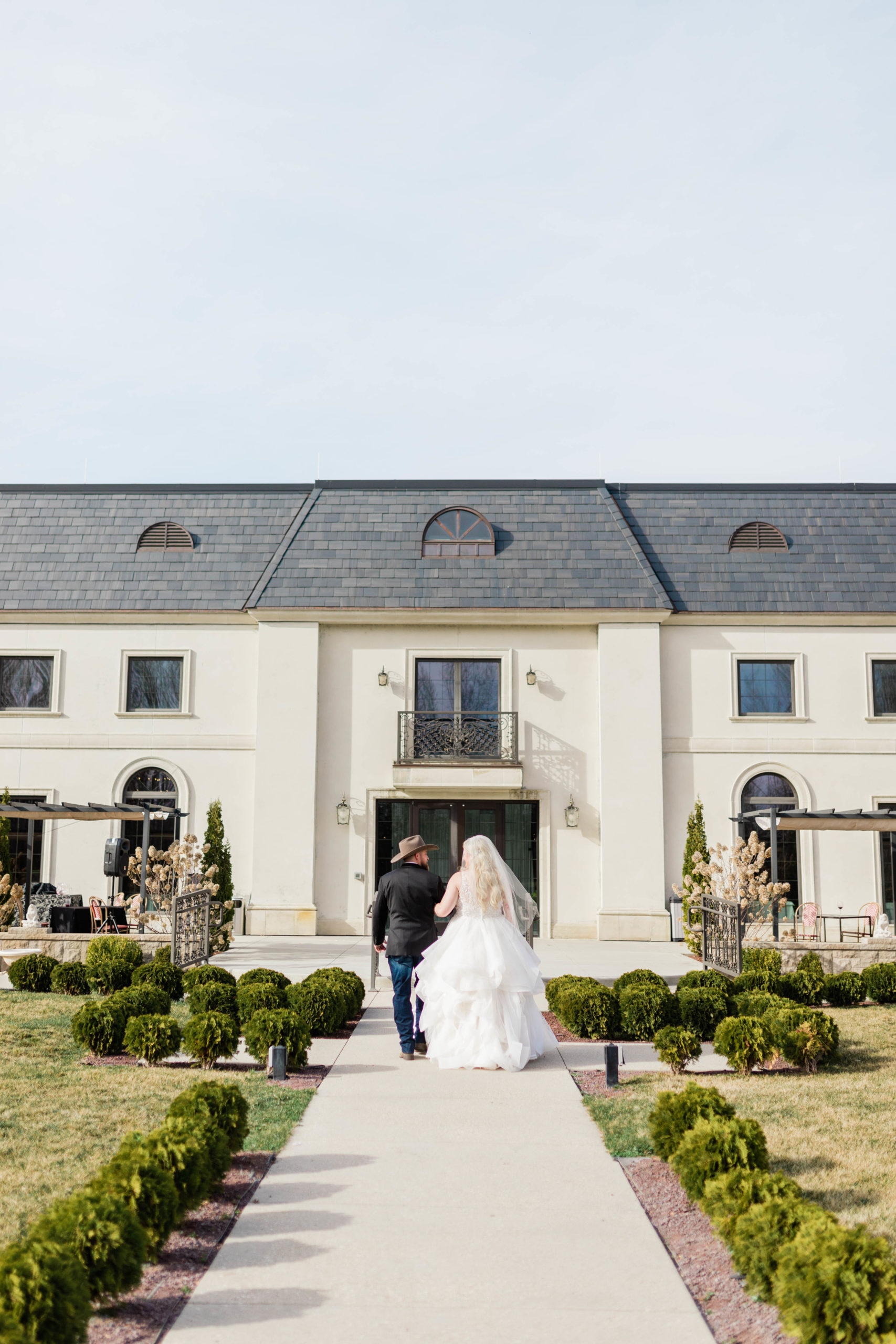 bride and groom walking into their luxury Boise wedding venue while holding hands captured by their Boise wedding photographer