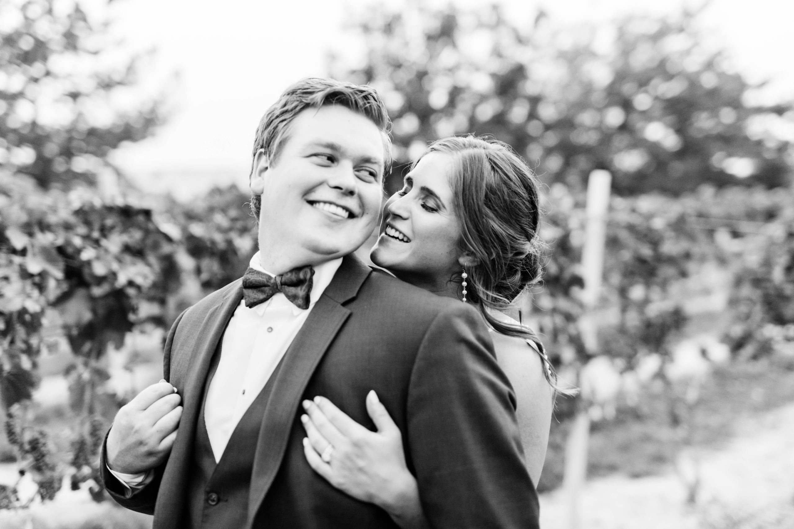 black and white wedding portrait of bride and groom embracing in a vineyard in Boise wedding