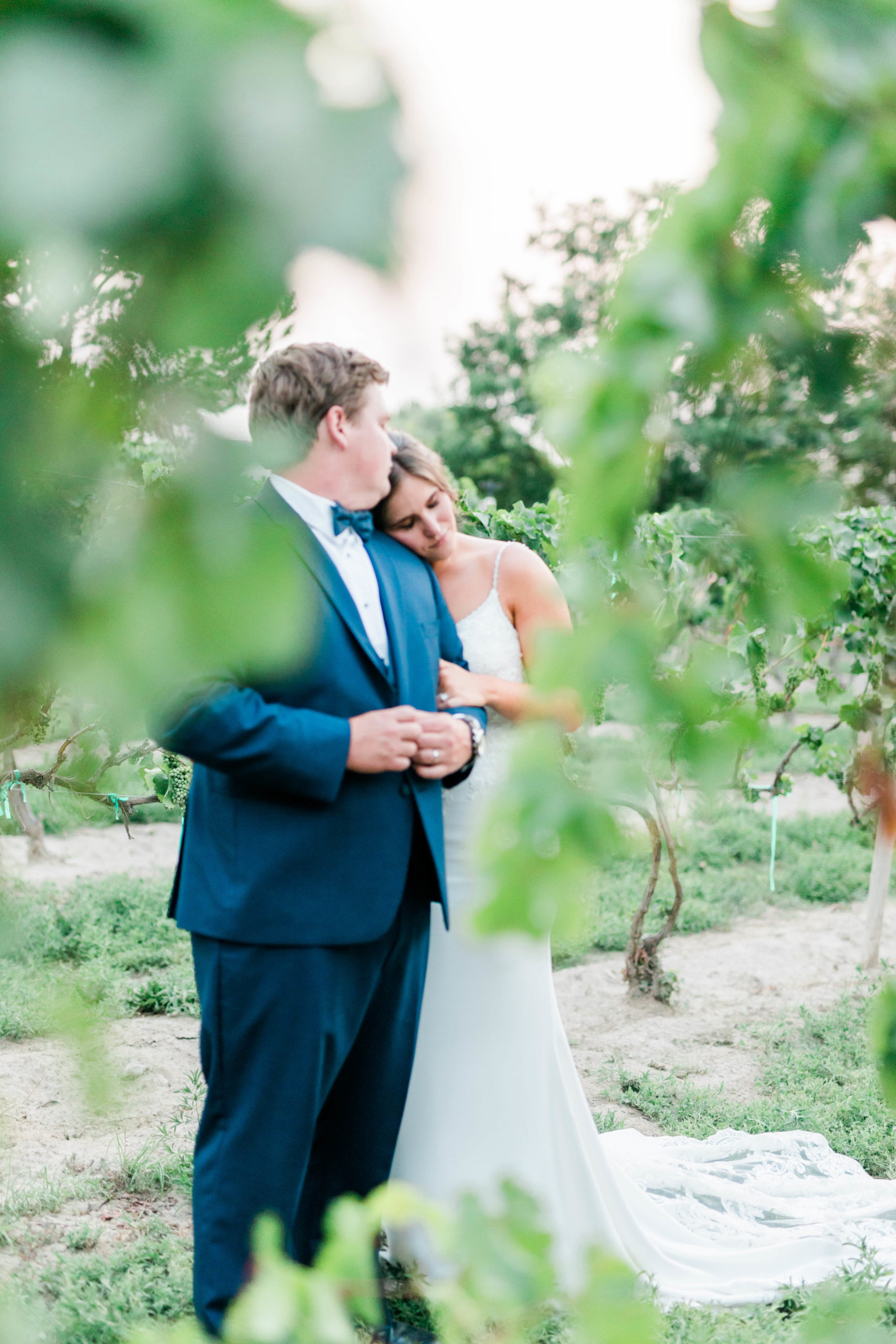 bride and groom embrace in a vineyard for their wedding day