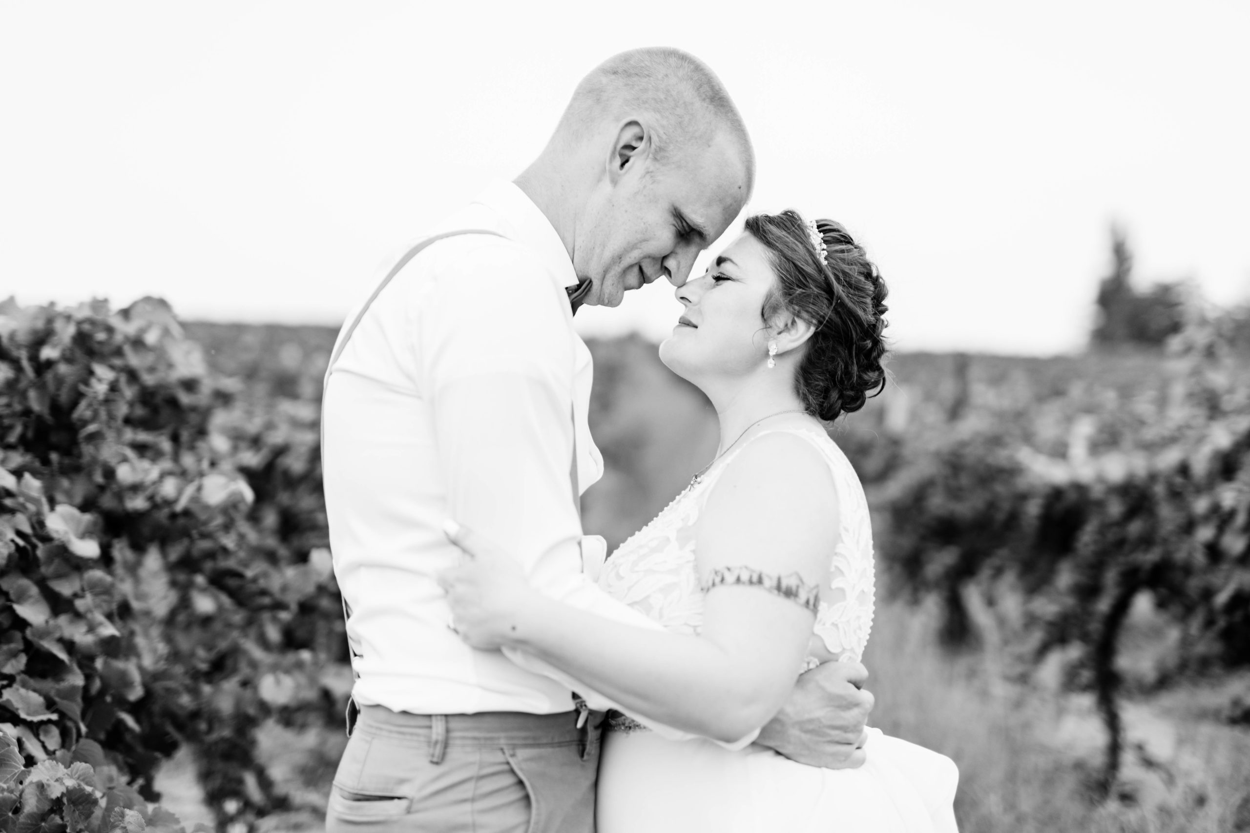 black and white wedding photos with bride and groom embracing are their foreheads and noses touch for a romantic summer wedding photo