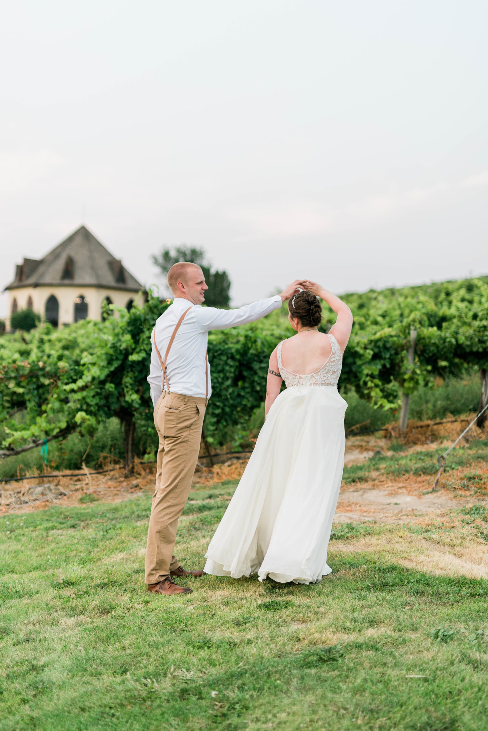 groom twirling his bride in a vineyard for their Boise wedding with Boise wedding photographer