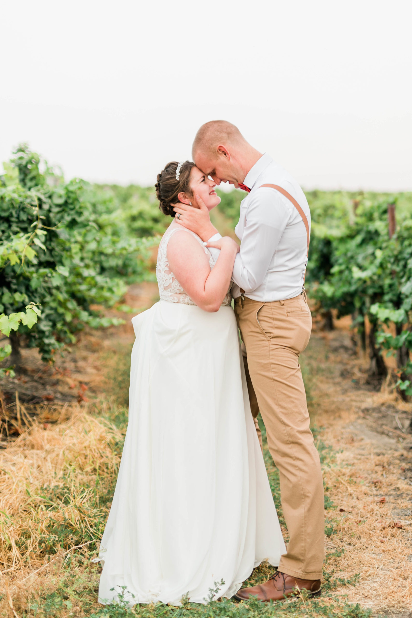 vineyard wedding with bride and groom in the vineyard embracing romantically captured by Boise wedding photographer