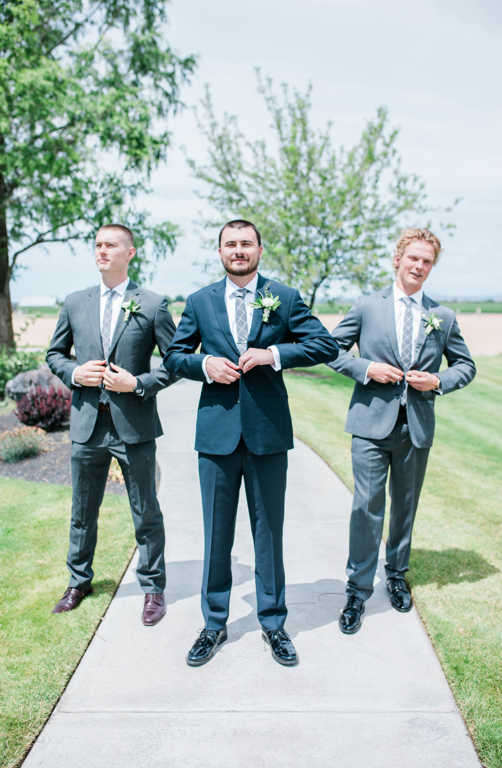 groomsmen and groom buttoning their suit coats 