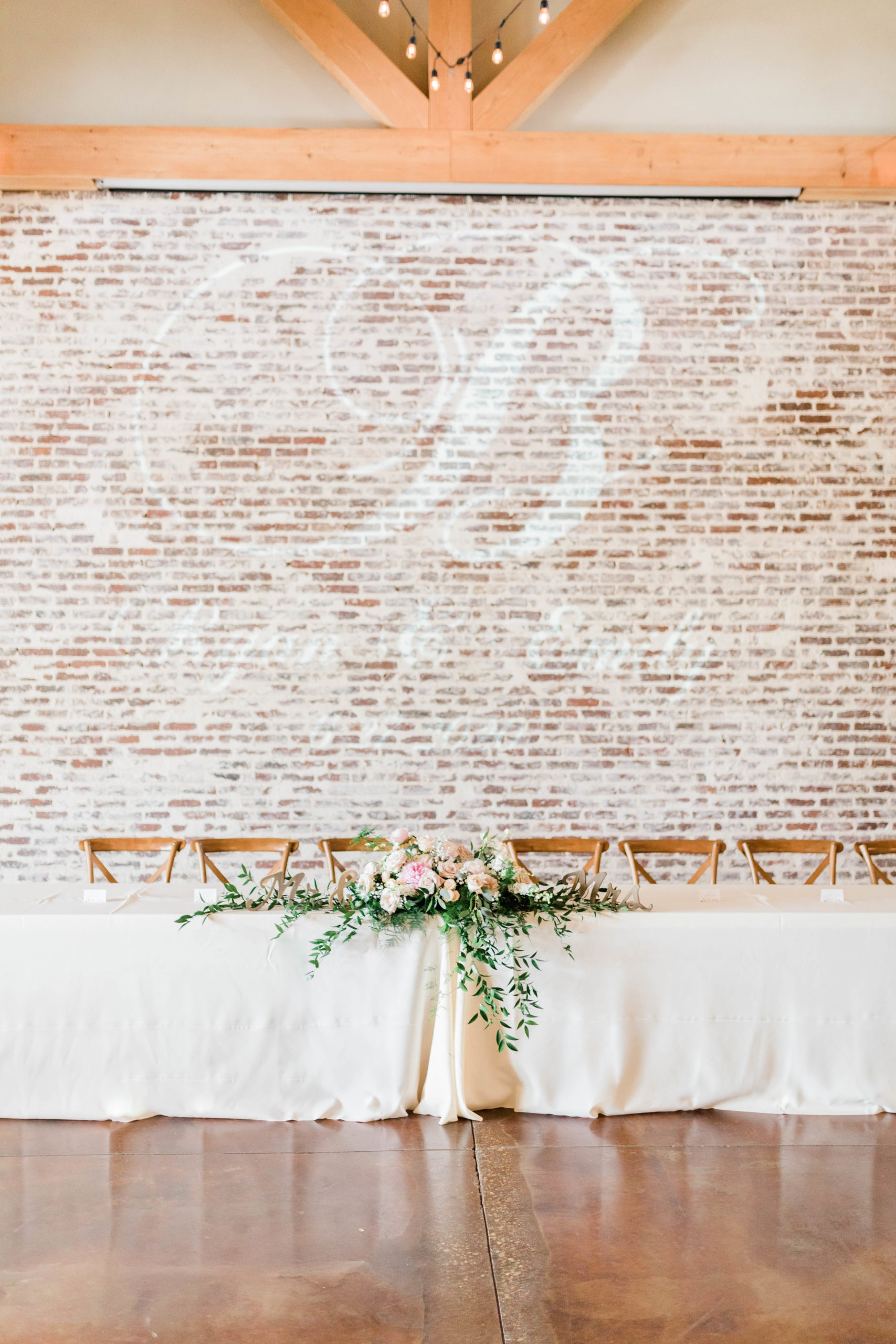 indoor reception space with exposed brick and white linen table clothes 