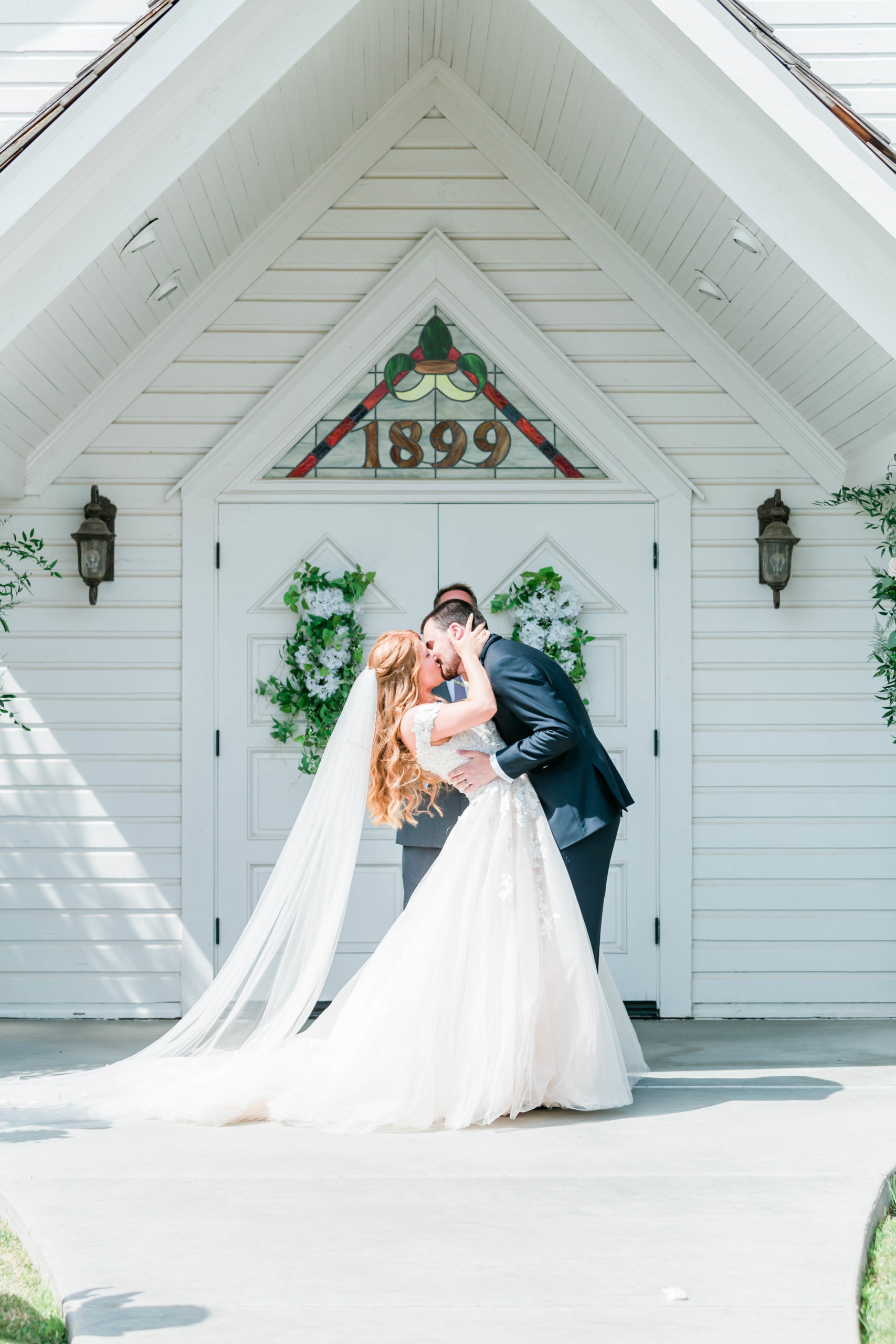 bride and groom having their first kiss as husband and wife at a white chapel captured by Boise wedding photographer