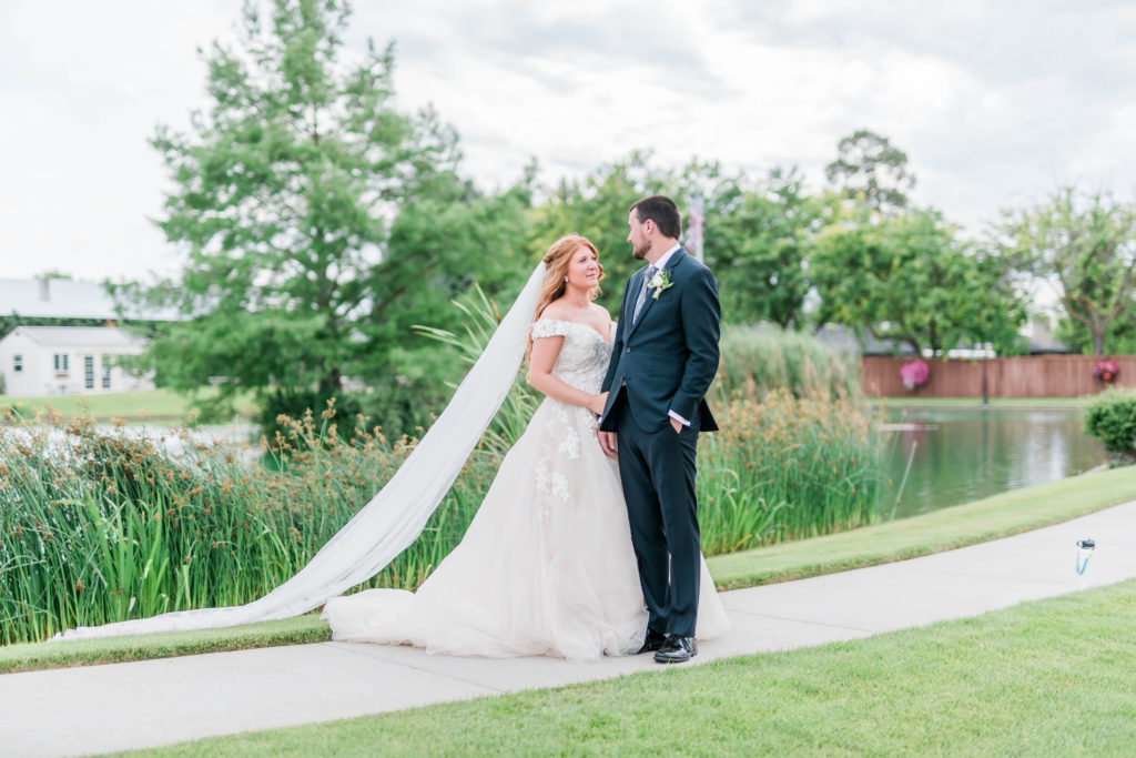 bride and groom holding each other next to a lake captured by Boise Wedding Photographer