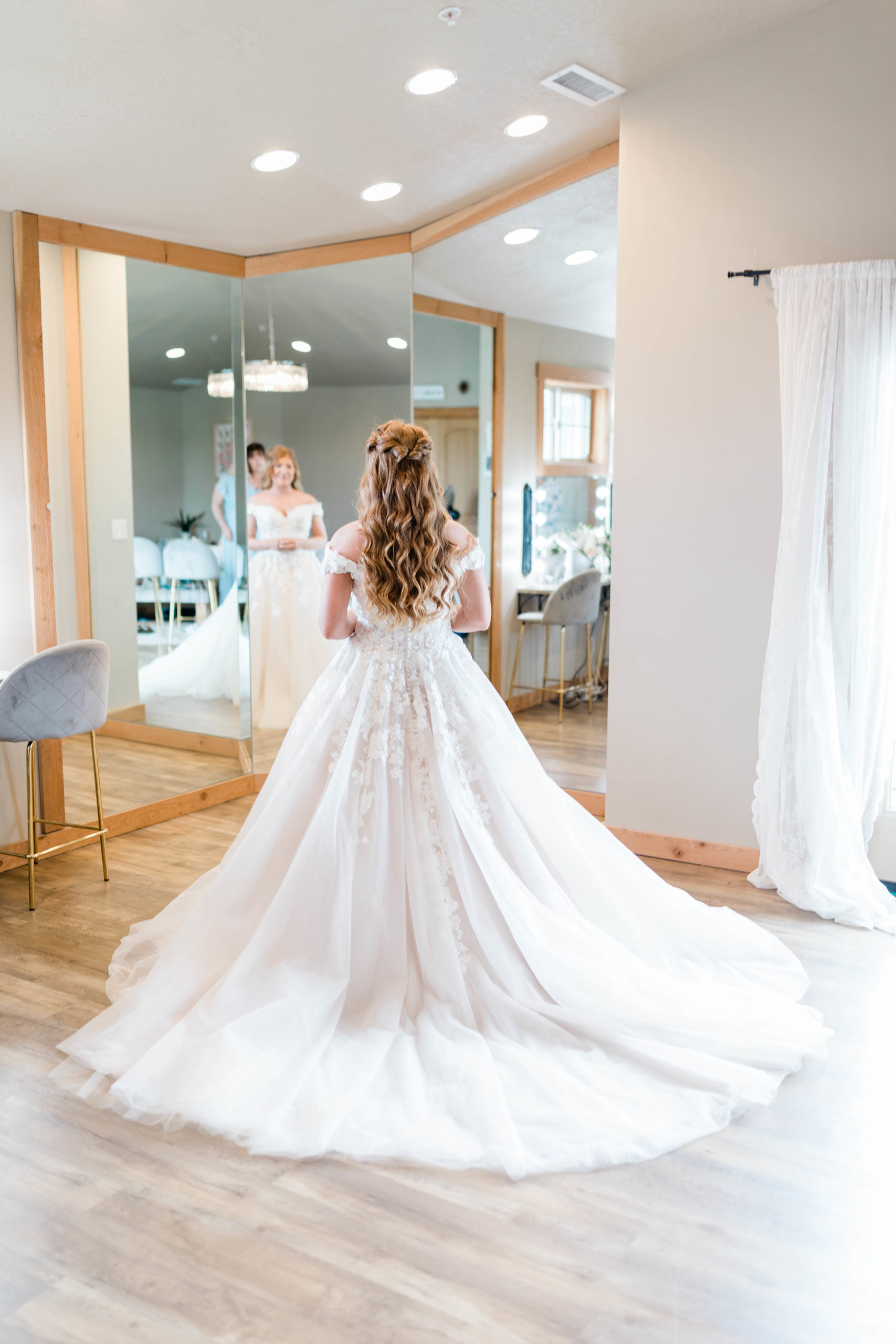 bride in her wedding gown standing in front of a mirror in her bridal suite photographed by Boise wedding photographer