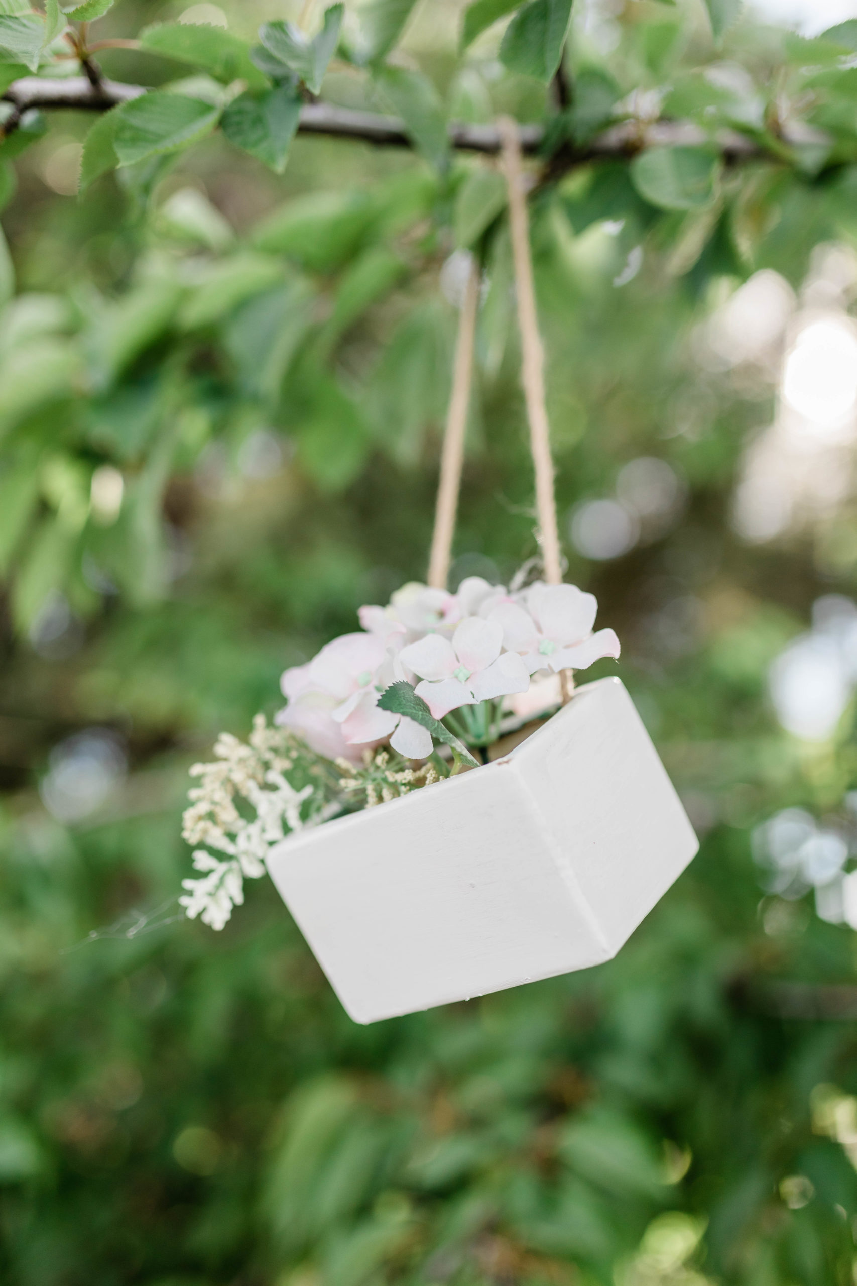 small box of flowers hanging from a tree for a boho backyard wedding in Boise