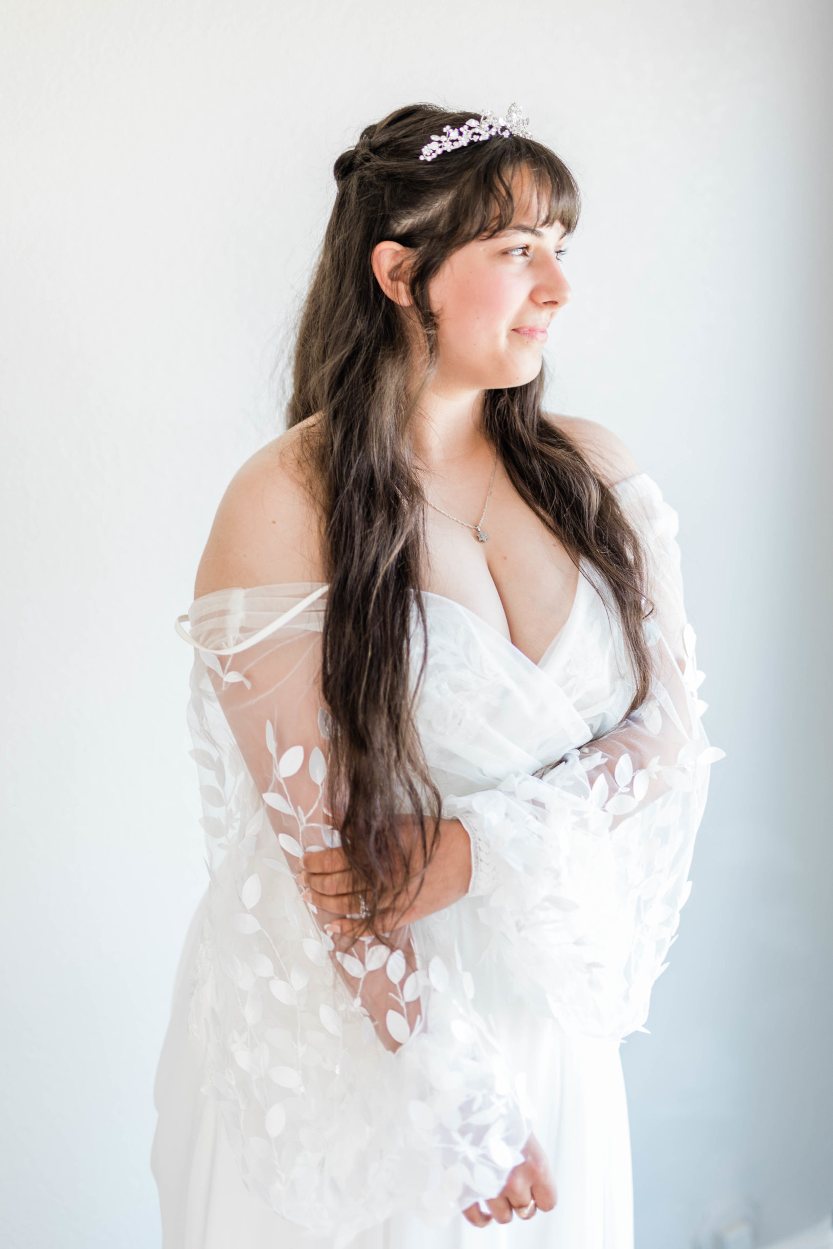 bridal portraits with bride holding her arm in a floral lace sleeve