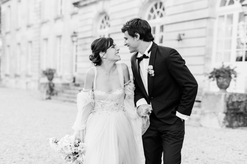 bride and groom holding hands and smiling with each other as they leave their wedding together taken by Boise Wedding Photographer