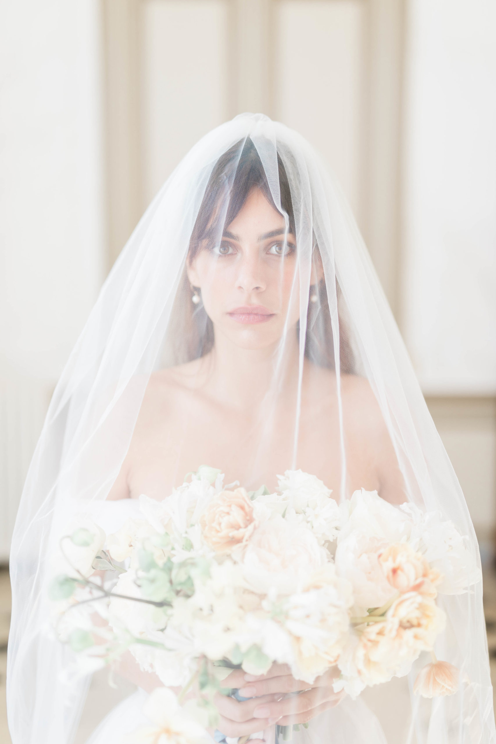 bride wearing veil and holding bouquet